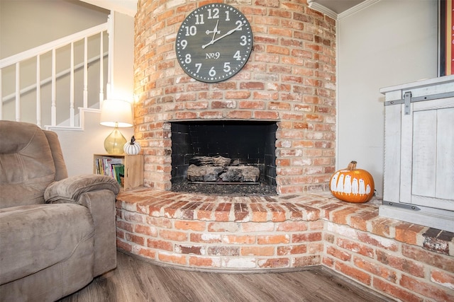 living room featuring ornamental molding, a fireplace, and hardwood / wood-style flooring