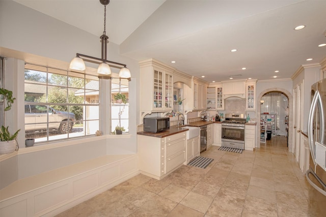 kitchen featuring decorative light fixtures, appliances with stainless steel finishes, and vaulted ceiling