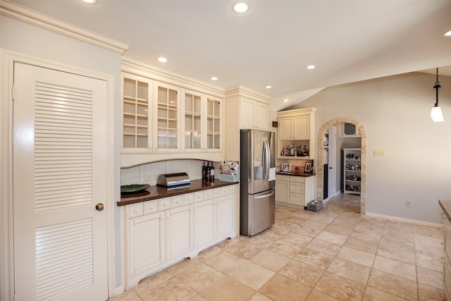 kitchen with vaulted ceiling, stainless steel fridge, ornamental molding, and pendant lighting