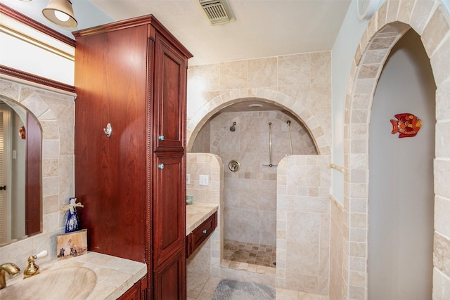 bathroom with vanity and tiled shower