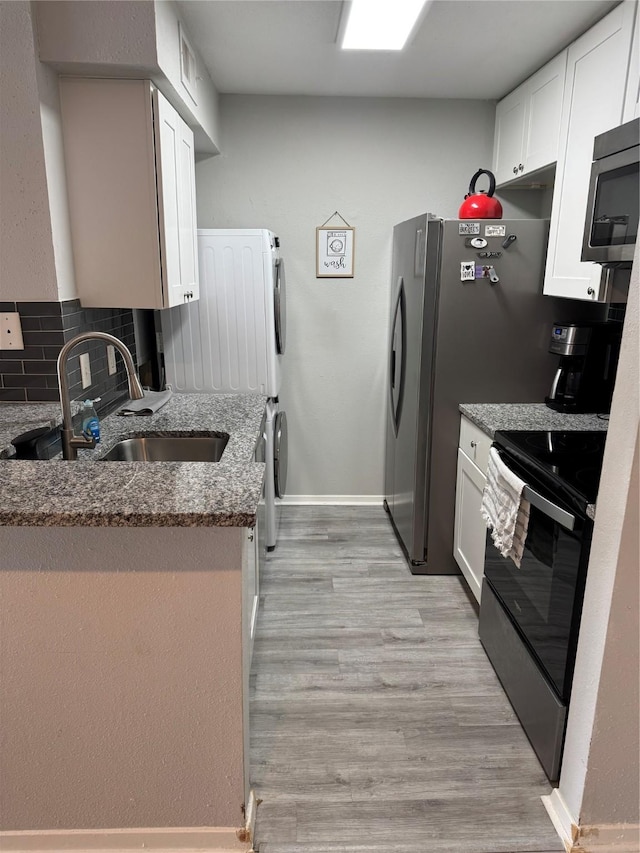 kitchen featuring white cabinets, backsplash, electric range, and stone countertops