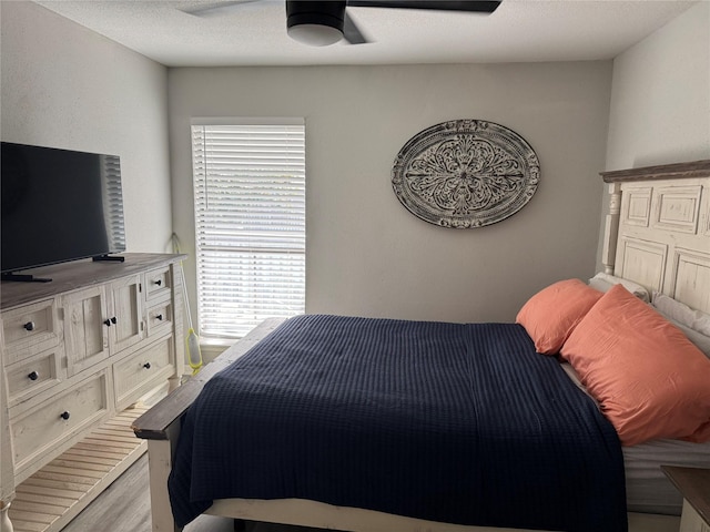 bedroom featuring ceiling fan, light wood-type flooring, and multiple windows