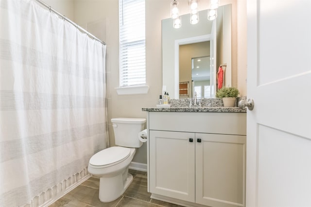 bathroom with toilet, vanity, and walk in shower