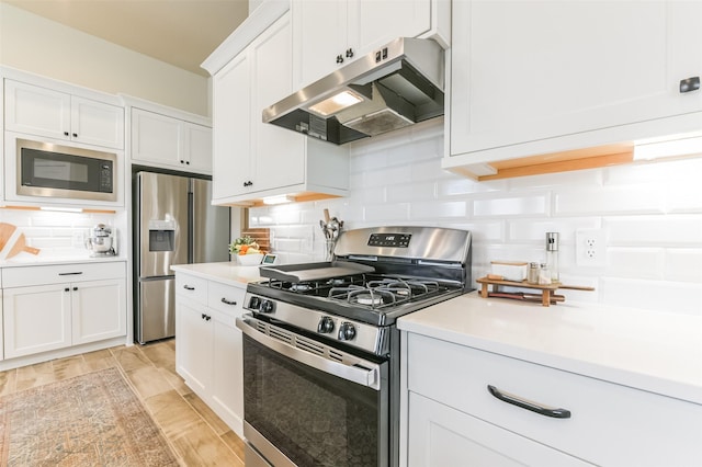 kitchen with appliances with stainless steel finishes, decorative backsplash, and white cabinets