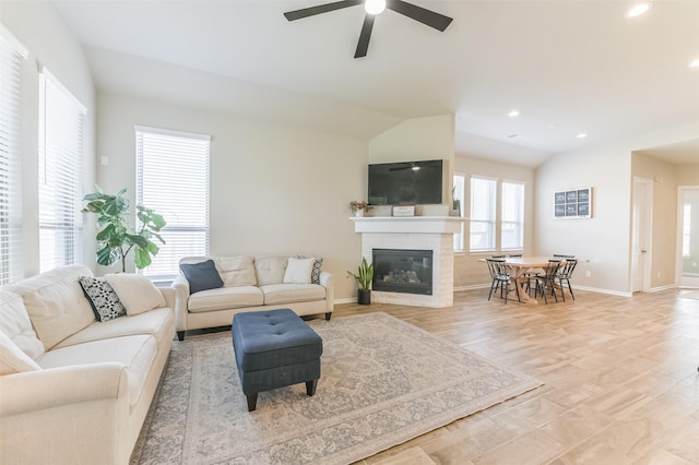 living room with vaulted ceiling, ceiling fan, and light hardwood / wood-style flooring