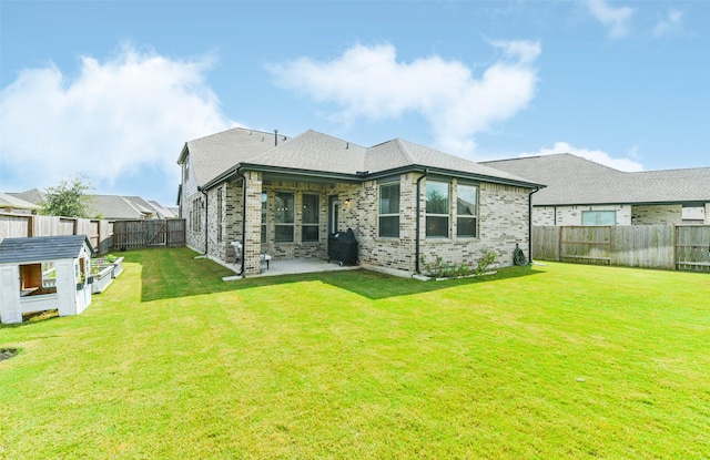 rear view of house with a patio area and a lawn