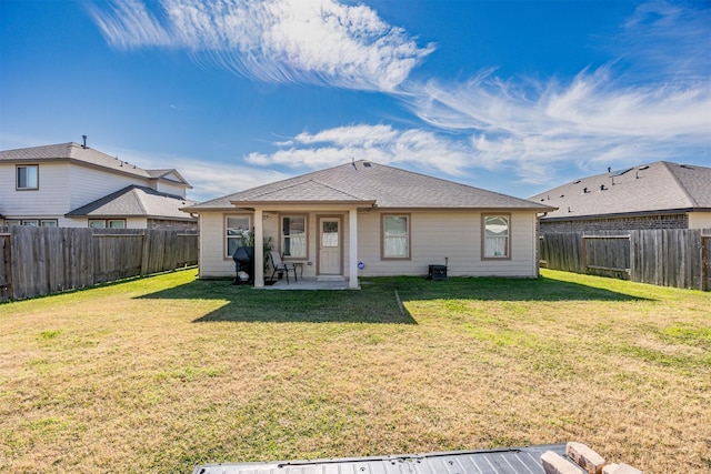 rear view of property featuring a patio area and a yard