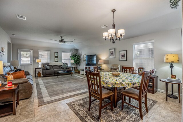 dining space featuring ceiling fan with notable chandelier and light tile patterned flooring