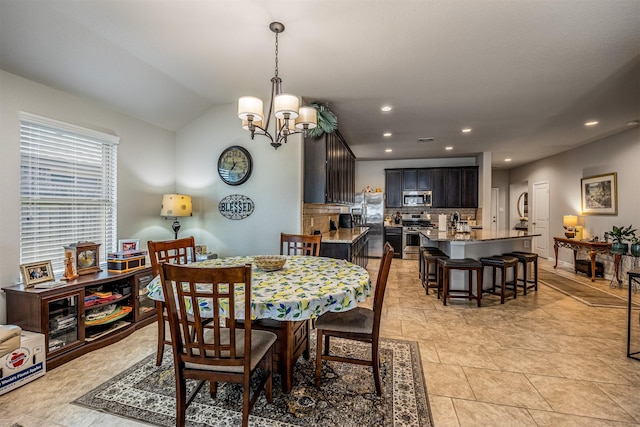 dining area featuring vaulted ceiling, light tile patterned floors, and a notable chandelier