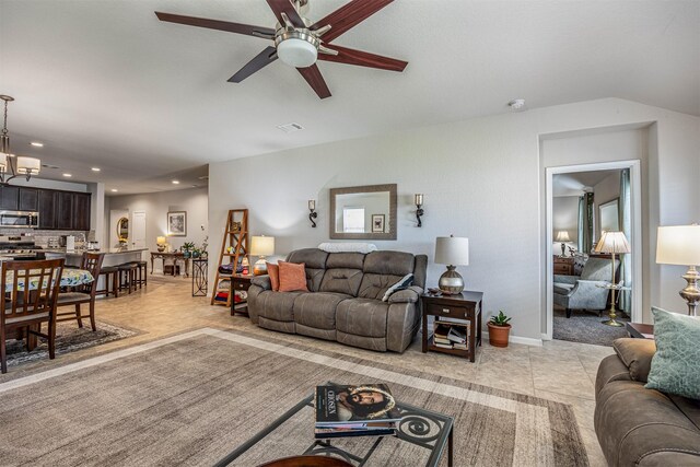 tiled living room featuring ceiling fan and lofted ceiling