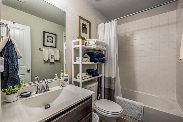 full bathroom featuring toilet, vanity, shower / bath combo with shower curtain, and a textured ceiling