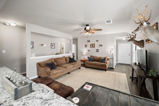 living room with ceiling fan and dark wood-type flooring