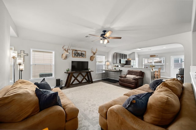 living room with ceiling fan, a wealth of natural light, and lofted ceiling