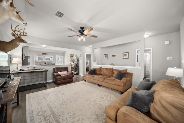 living room with ceiling fan and dark hardwood / wood-style flooring