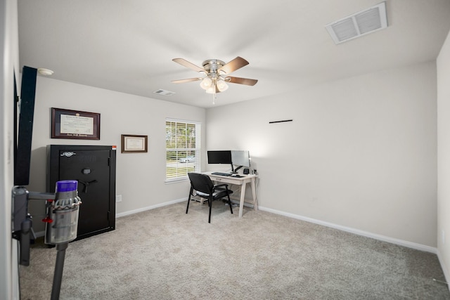 carpeted home office featuring ceiling fan