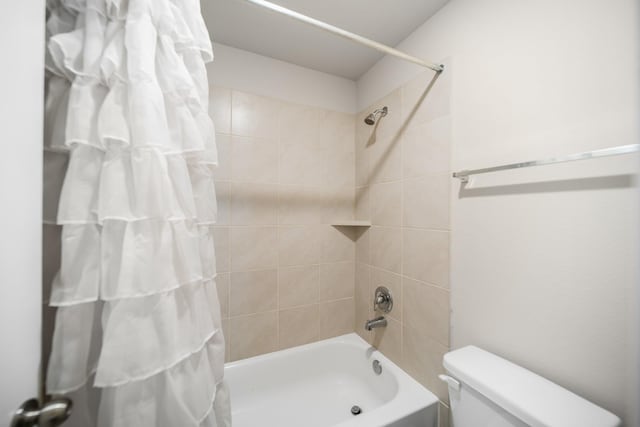 bathroom featuring toilet and shower / bathtub combination with curtain