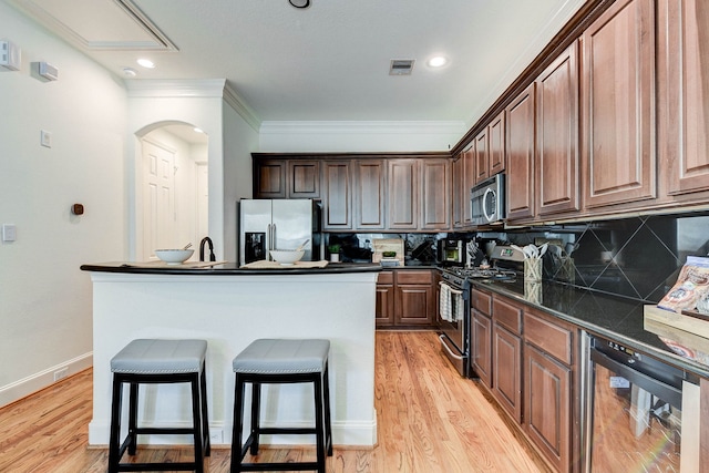 kitchen with beverage cooler, appliances with stainless steel finishes, a center island with sink, and tasteful backsplash