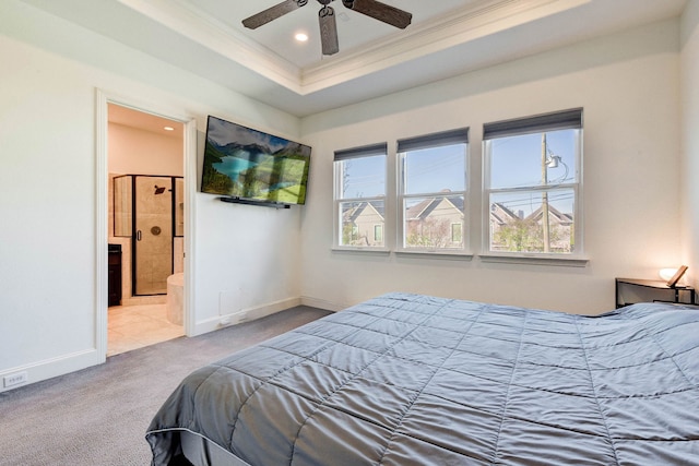 carpeted bedroom featuring ceiling fan, crown molding, connected bathroom, and a tray ceiling