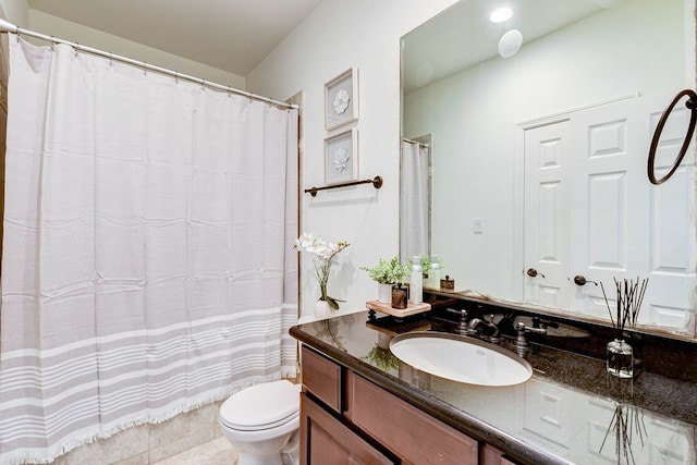 bathroom with toilet, vanity, and tile patterned flooring