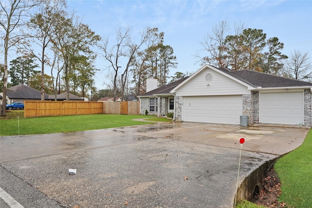 ranch-style home featuring a garage and a front lawn