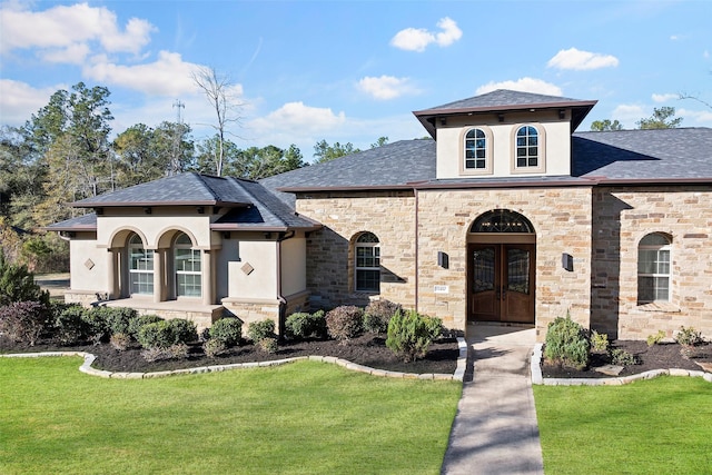 view of front facade featuring french doors, a front lawn, roof with shingles, and stucco siding