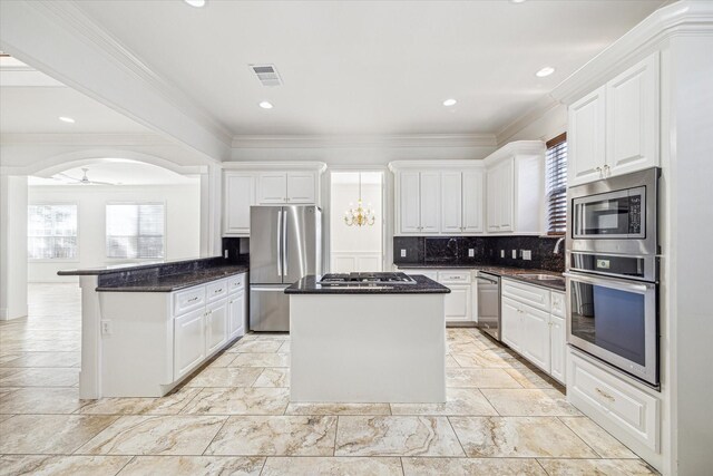 4505 Mimosa Dr, Bellaire, TX 77401 - kitchen with white cabinets, plenty of natural light, stainless steel appliances, and a center island