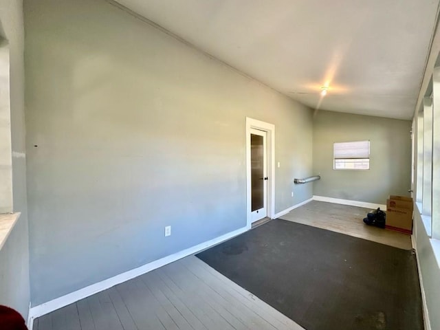 empty room featuring vaulted ceiling and dark hardwood / wood-style floors