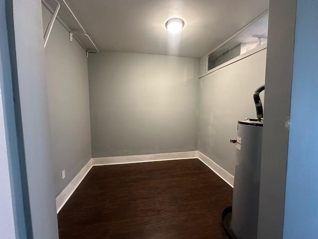 walk in closet featuring dark wood-type flooring and water heater