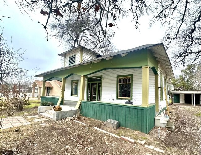 view of side of home with covered porch