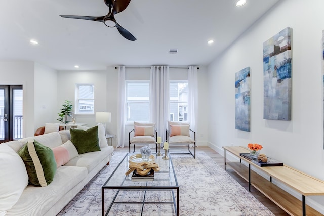 living room with a wealth of natural light, light hardwood / wood-style floors, and ceiling fan