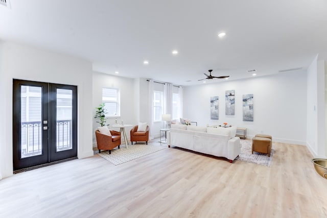 living room with light hardwood / wood-style flooring, ceiling fan, and french doors