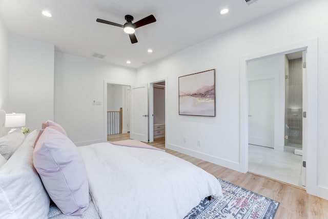 bedroom with ceiling fan, ensuite bath, and light hardwood / wood-style floors