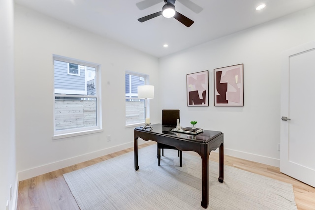 office featuring a wealth of natural light, ceiling fan, and light hardwood / wood-style flooring