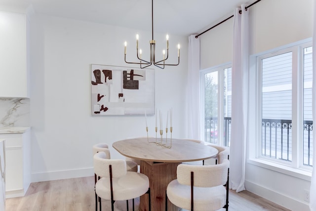 dining area featuring an inviting chandelier, plenty of natural light, and light hardwood / wood-style floors