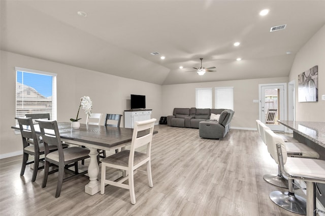 dining room with ceiling fan, lofted ceiling, and light hardwood / wood-style floors