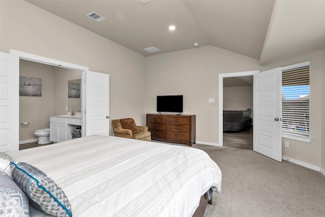 carpeted bedroom with vaulted ceiling and ensuite bath