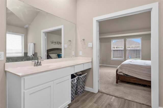 bathroom featuring lofted ceiling, vanity, plenty of natural light, and hardwood / wood-style floors