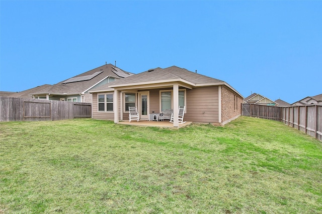 back of house featuring a lawn and a patio