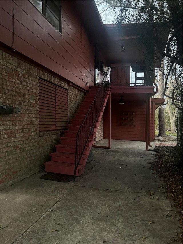 view of side of property with brick siding and stairs