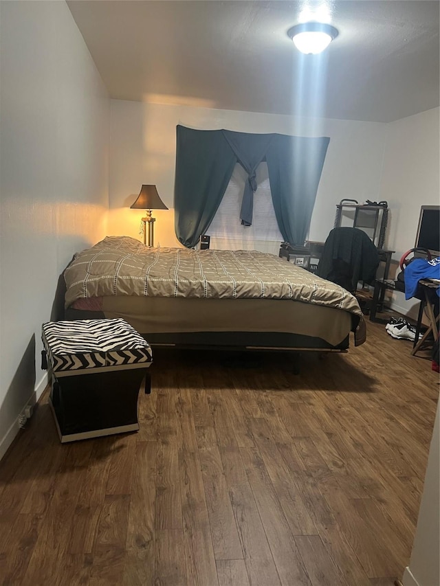 bedroom with wood finished floors and baseboards