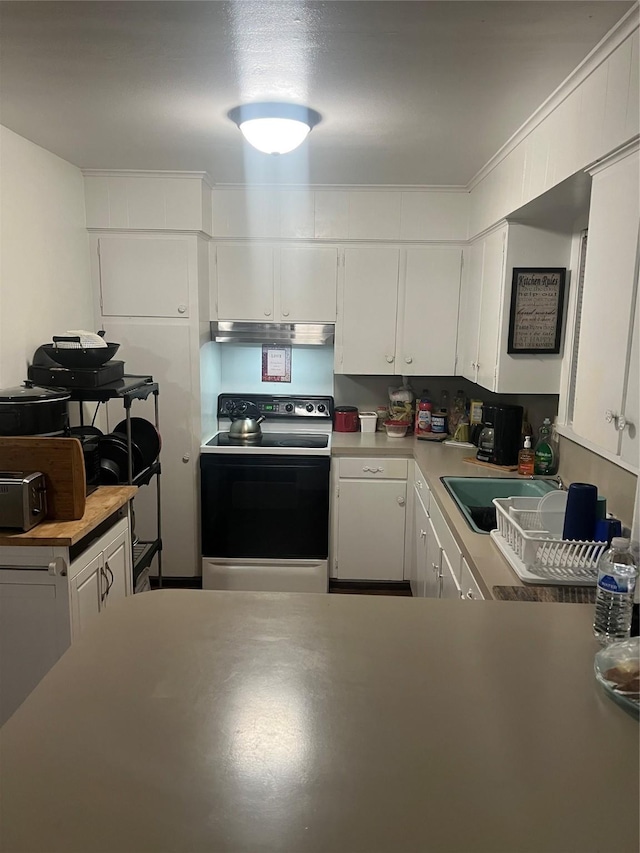 kitchen featuring under cabinet range hood, light countertops, electric stove, white cabinets, and a sink