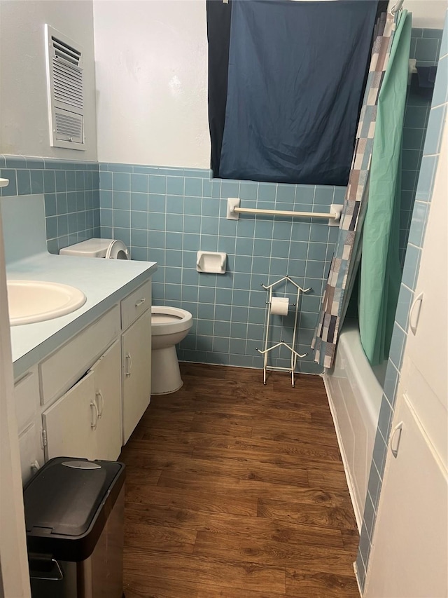 bathroom with toilet, tile walls, wood finished floors, and vanity