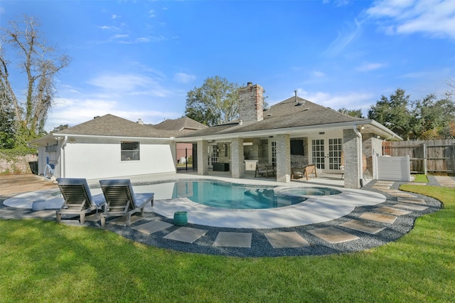 back of property with a fenced in pool, a yard, french doors, and a patio