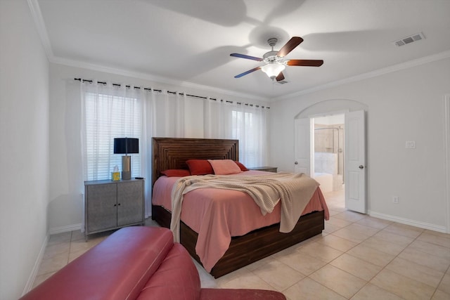 tiled bedroom featuring ceiling fan, ornamental molding, and ensuite bath