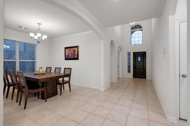 foyer with light tile patterned floors, ornamental molding, and a notable chandelier