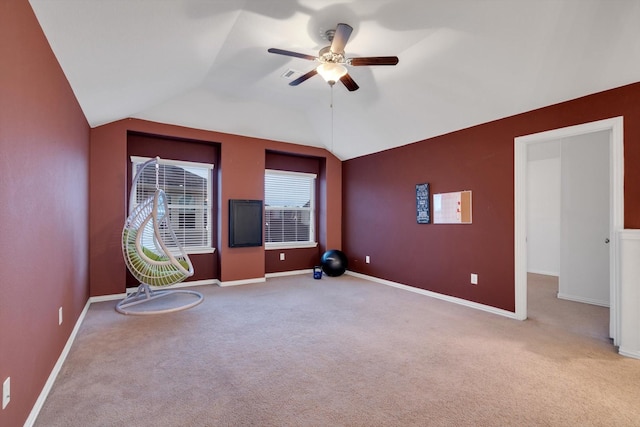 interior space featuring ceiling fan, light colored carpet, and vaulted ceiling