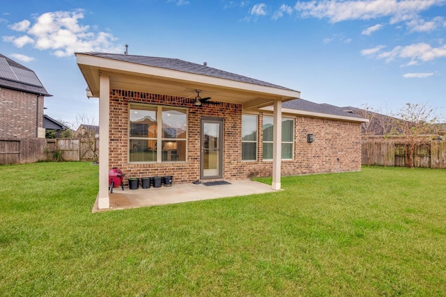 rear view of property with a patio area, a yard, and ceiling fan