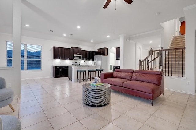 living room with ceiling fan, light tile patterned floors, and crown molding