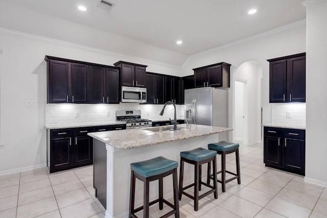 kitchen with an island with sink, light tile patterned floors, appliances with stainless steel finishes, and sink