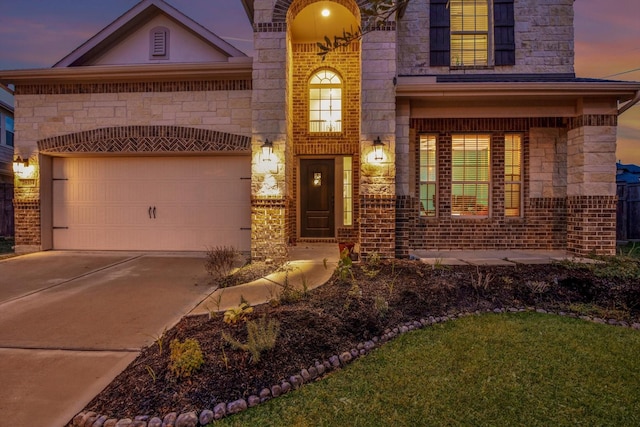 exterior entry at dusk featuring a garage